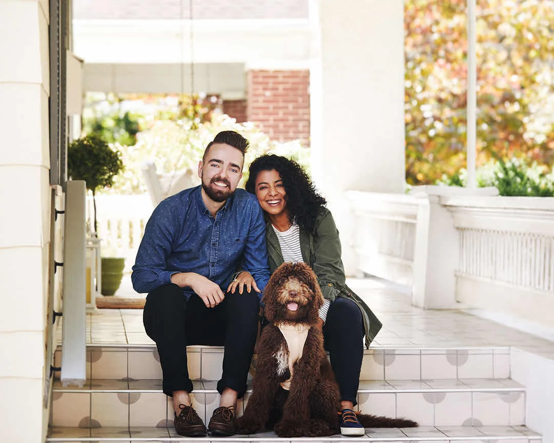 Couple sitting on porch with dog